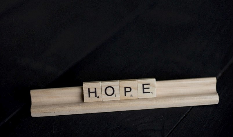 Scrabble letters spelling HOPE.
